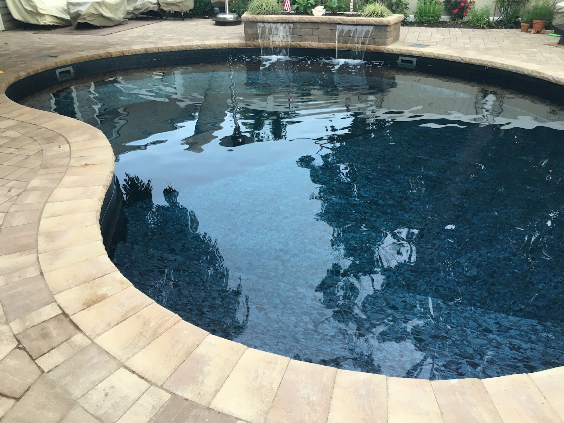 A large swimming pool with a fountain in the middle