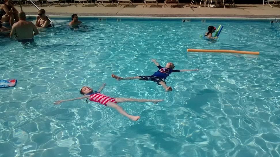 A group of people are swimming in a swimming pool.