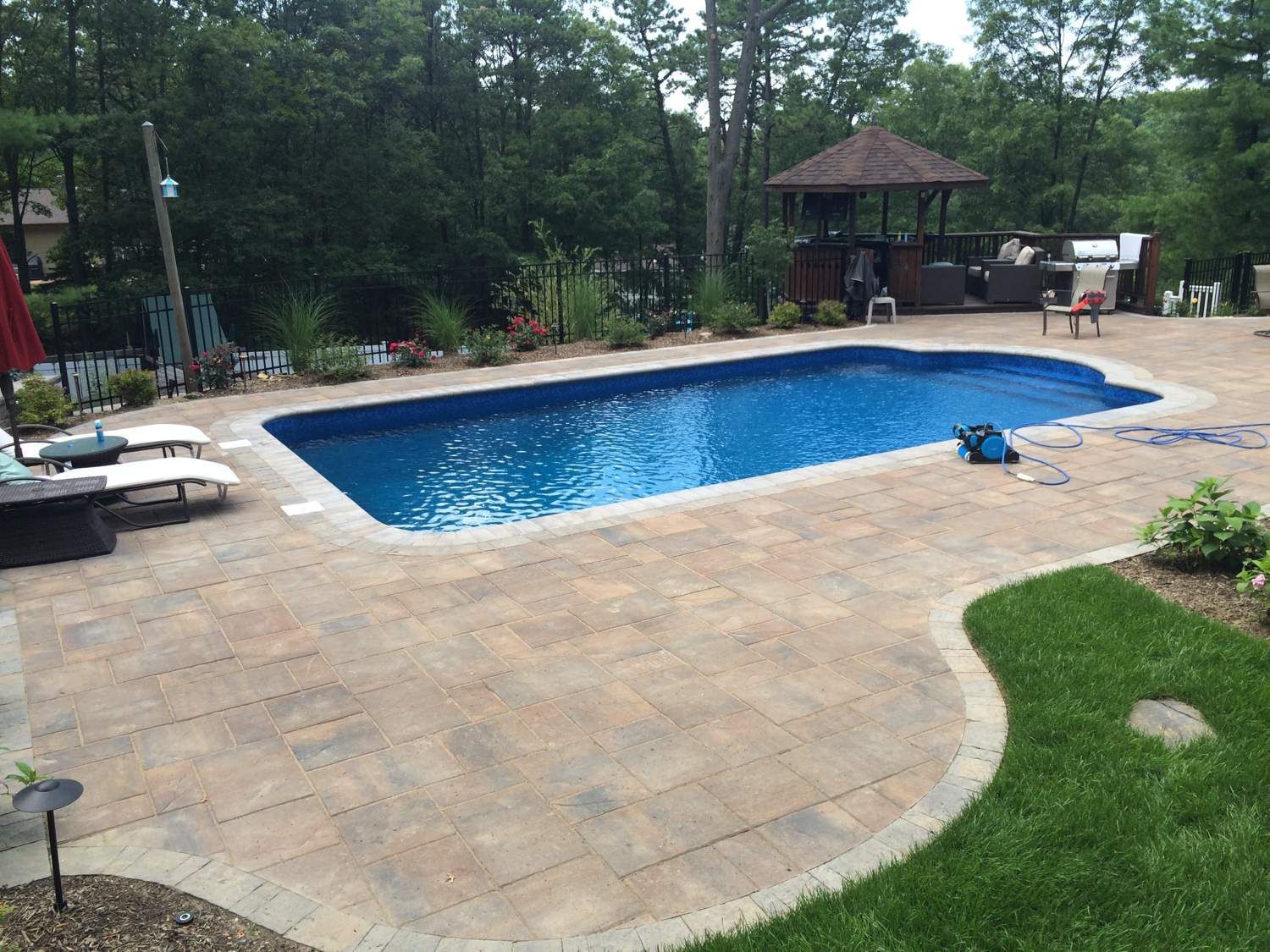 A large swimming pool with a gazebo in the background
