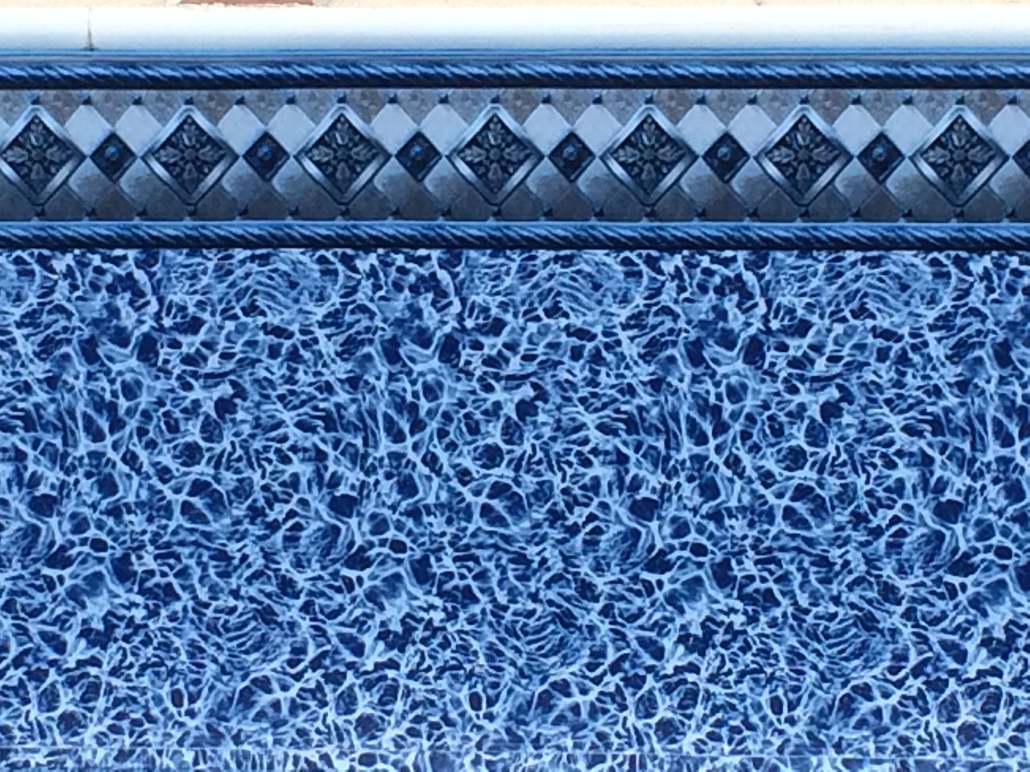 A blue and white tile with a diamond pattern on it