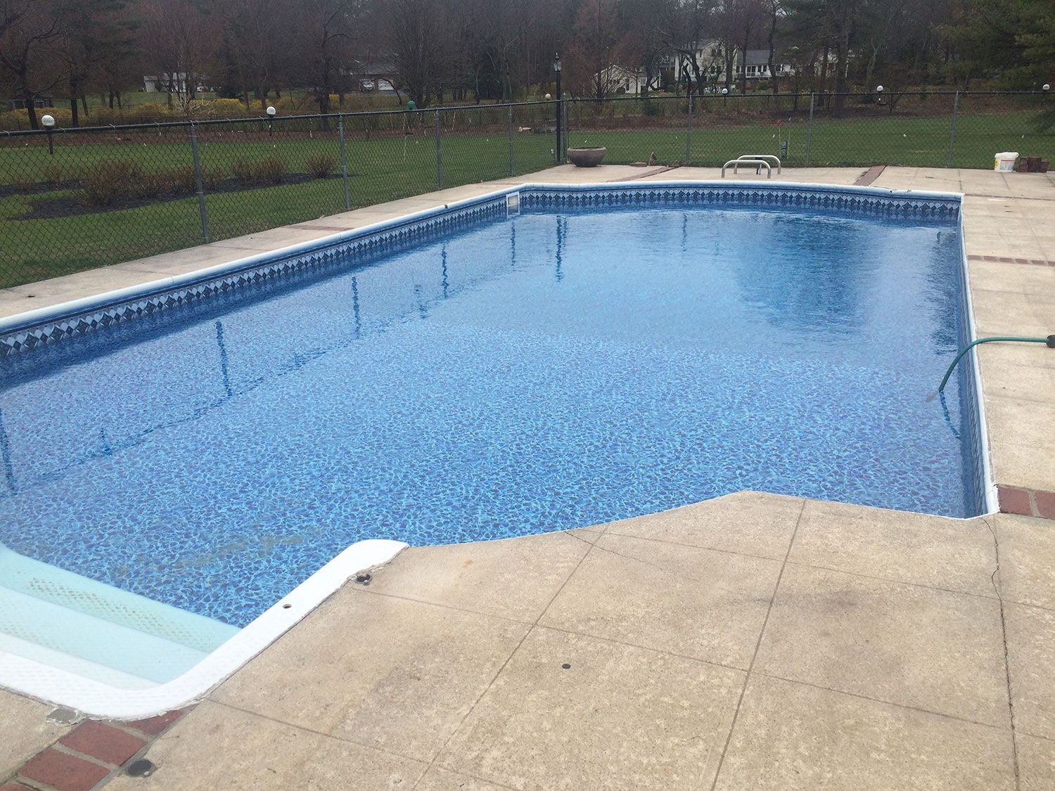A large swimming pool with a hose attached to the side of it.