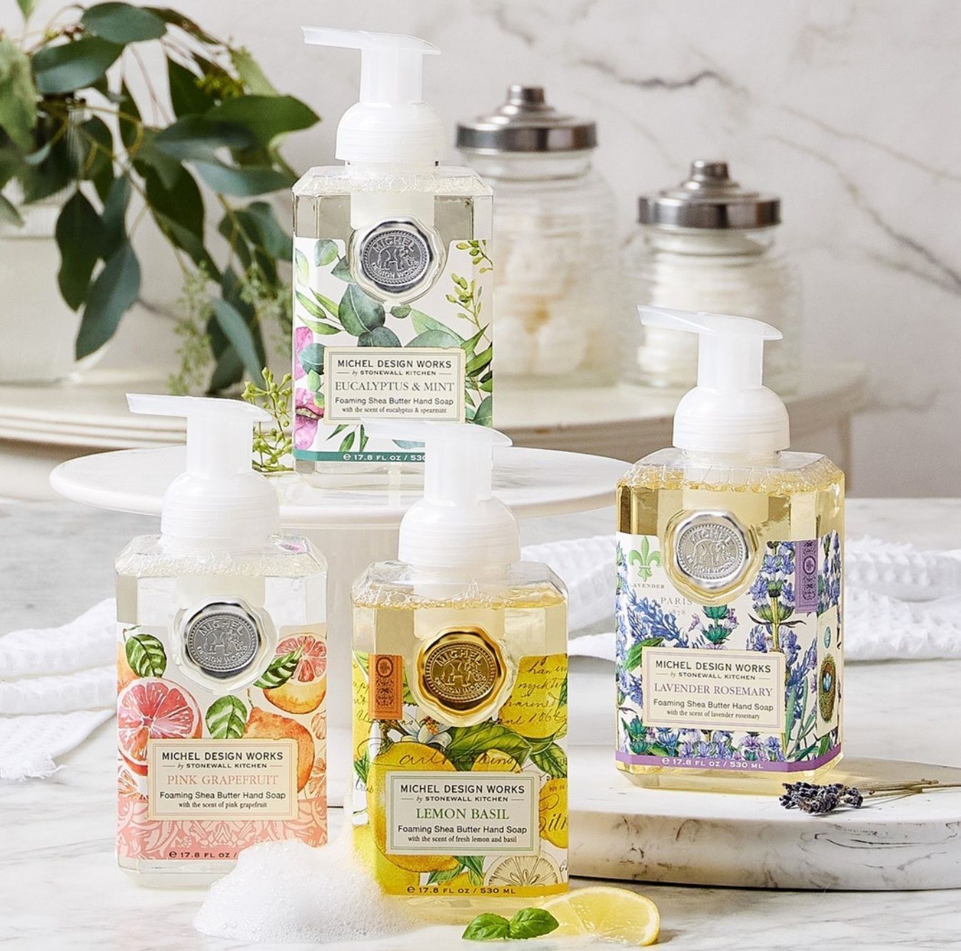 Four bottles of foaming hand soap are sitting on a table.