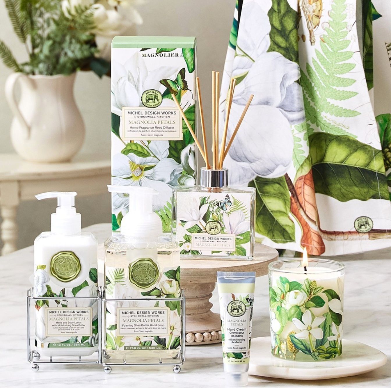 A table topped with bottles of soap , lotion , and candles.