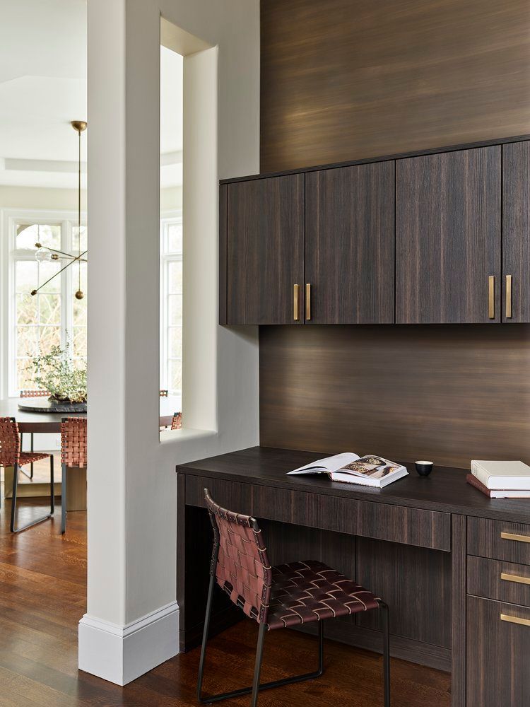 A desk with a chair and a book on it in a room.