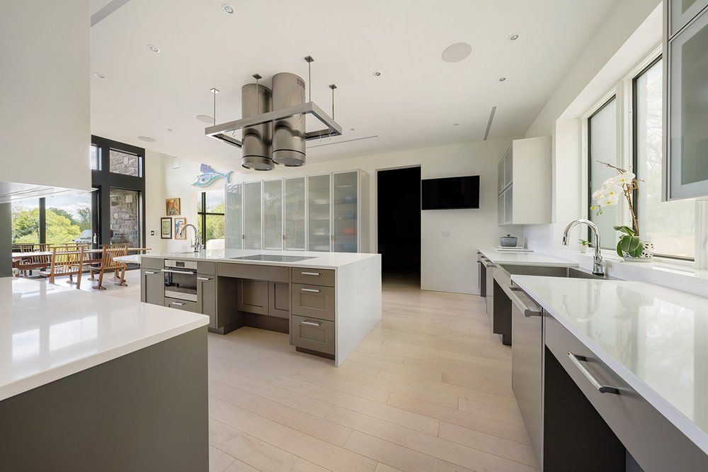 A large kitchen with white counter tops and stainless steel appliances.