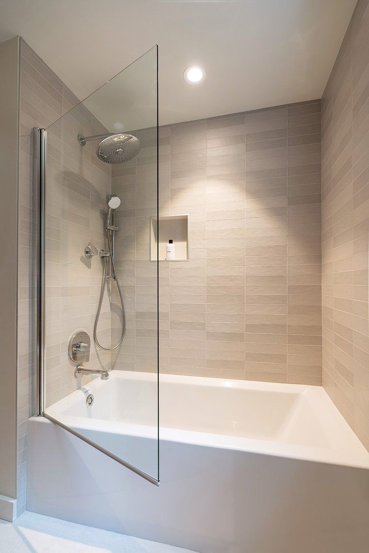 A bathroom with a bathtub and a shower stall with a glass door.