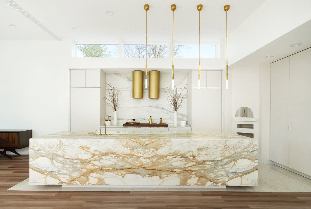 A kitchen with a large marble island in the middle of the room.