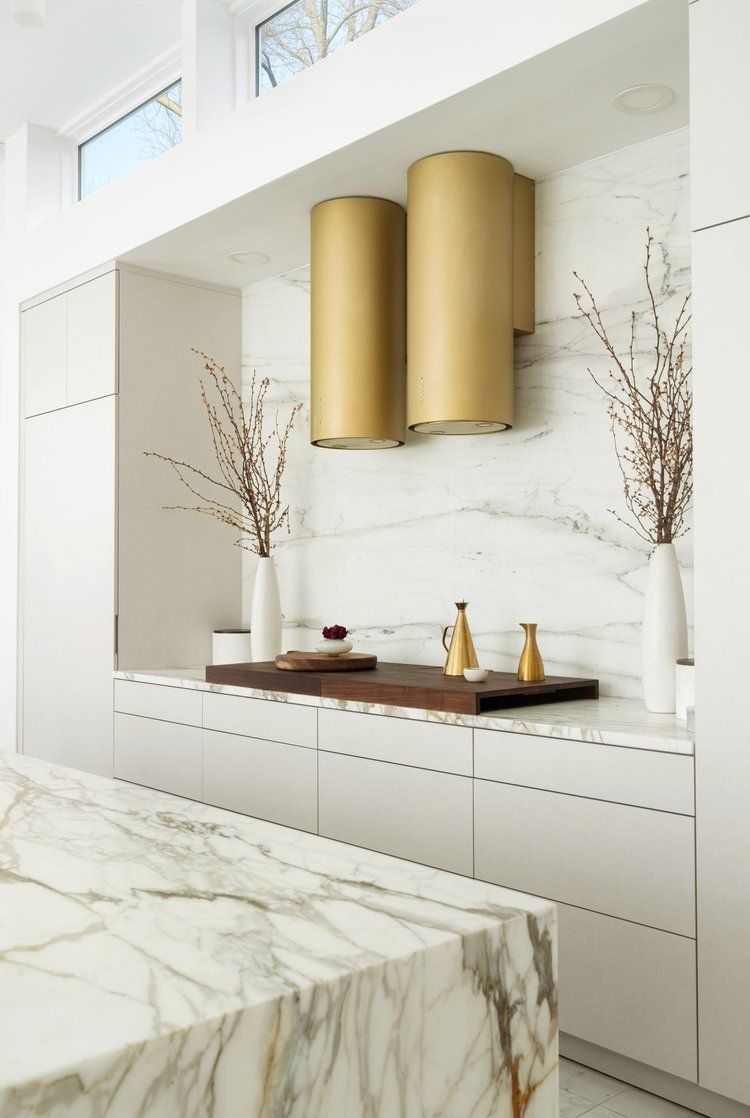 A kitchen with white cabinets and marble counter tops
