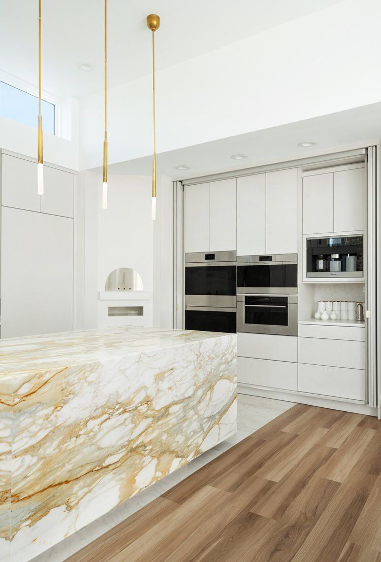 A kitchen with a marble counter top and stainless steel appliances