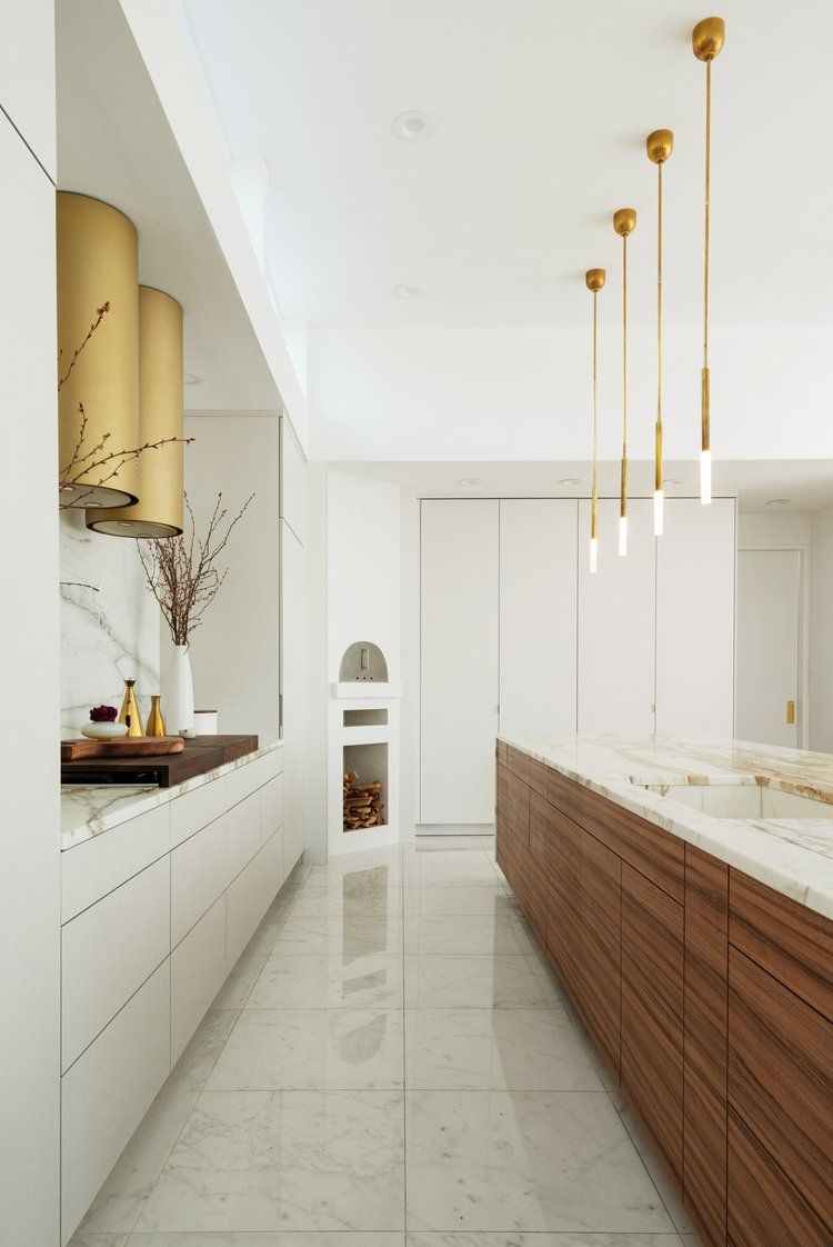A kitchen with white cabinets and wooden cabinets and a marble floor.