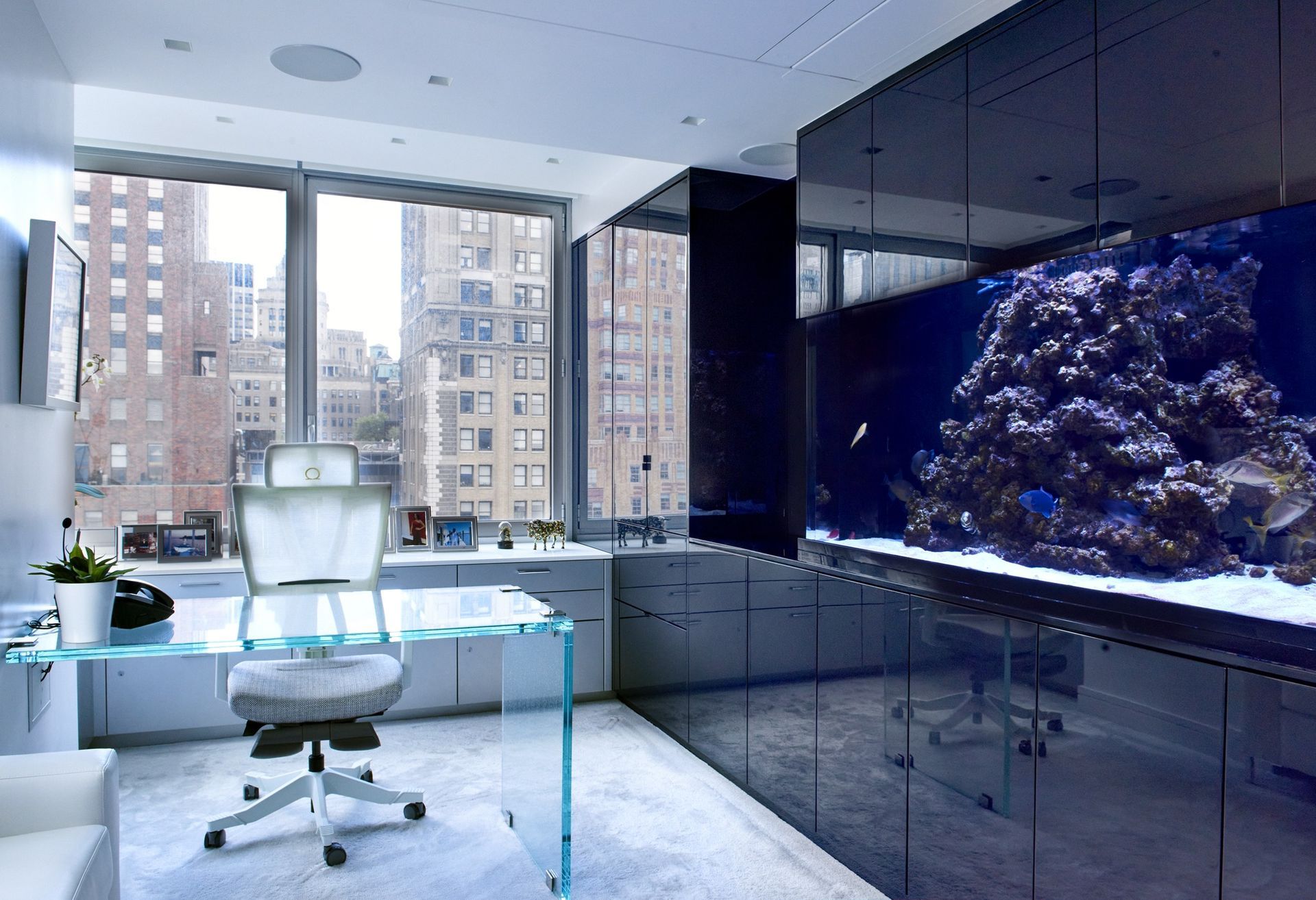 A home office with a large aquarium on the wall