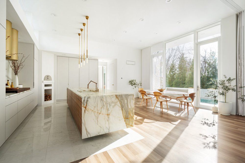 A kitchen and dining room in a house with a large island in the middle.