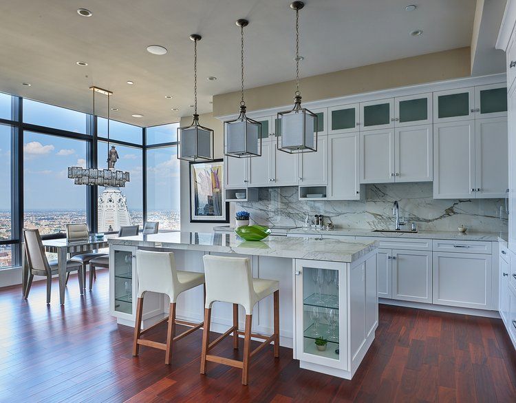 A kitchen with white cabinets and a large island