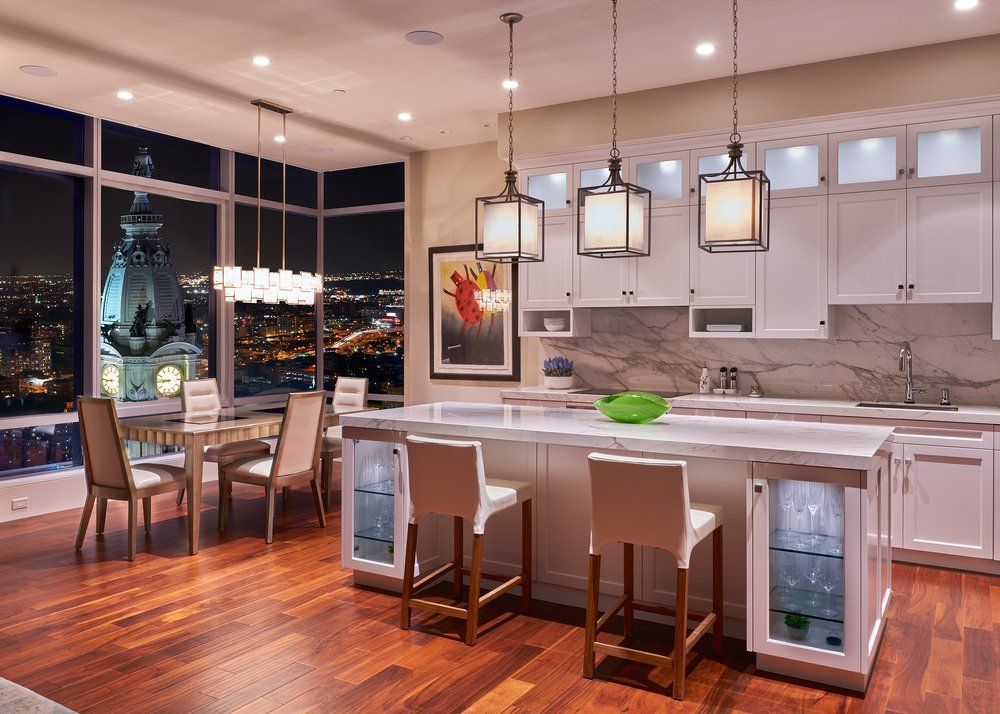 A kitchen and dining room with a view of the city at night.