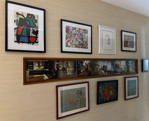 A wall with a lot of framed pictures on it.