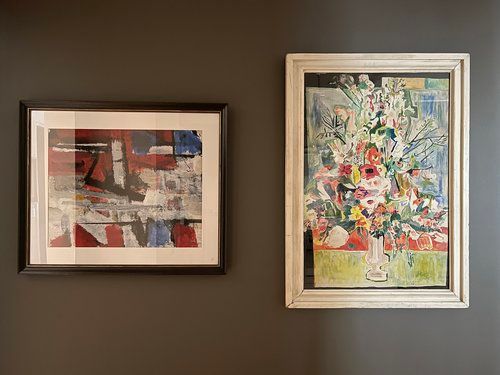 Two paintings are hanging on a wall next to each other.