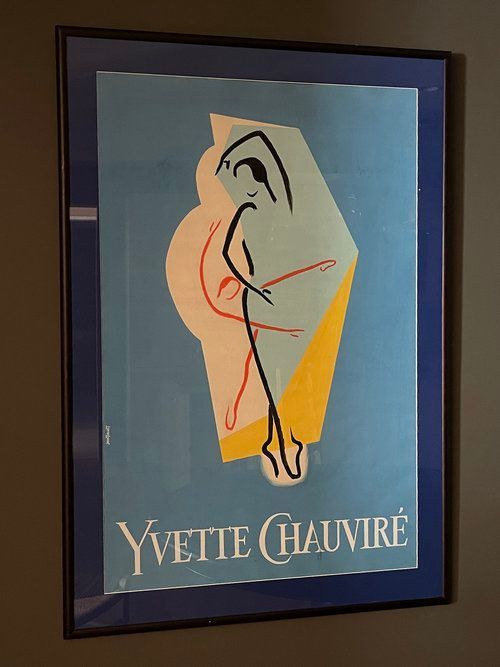 A framed yvette chauvire poster on a wall