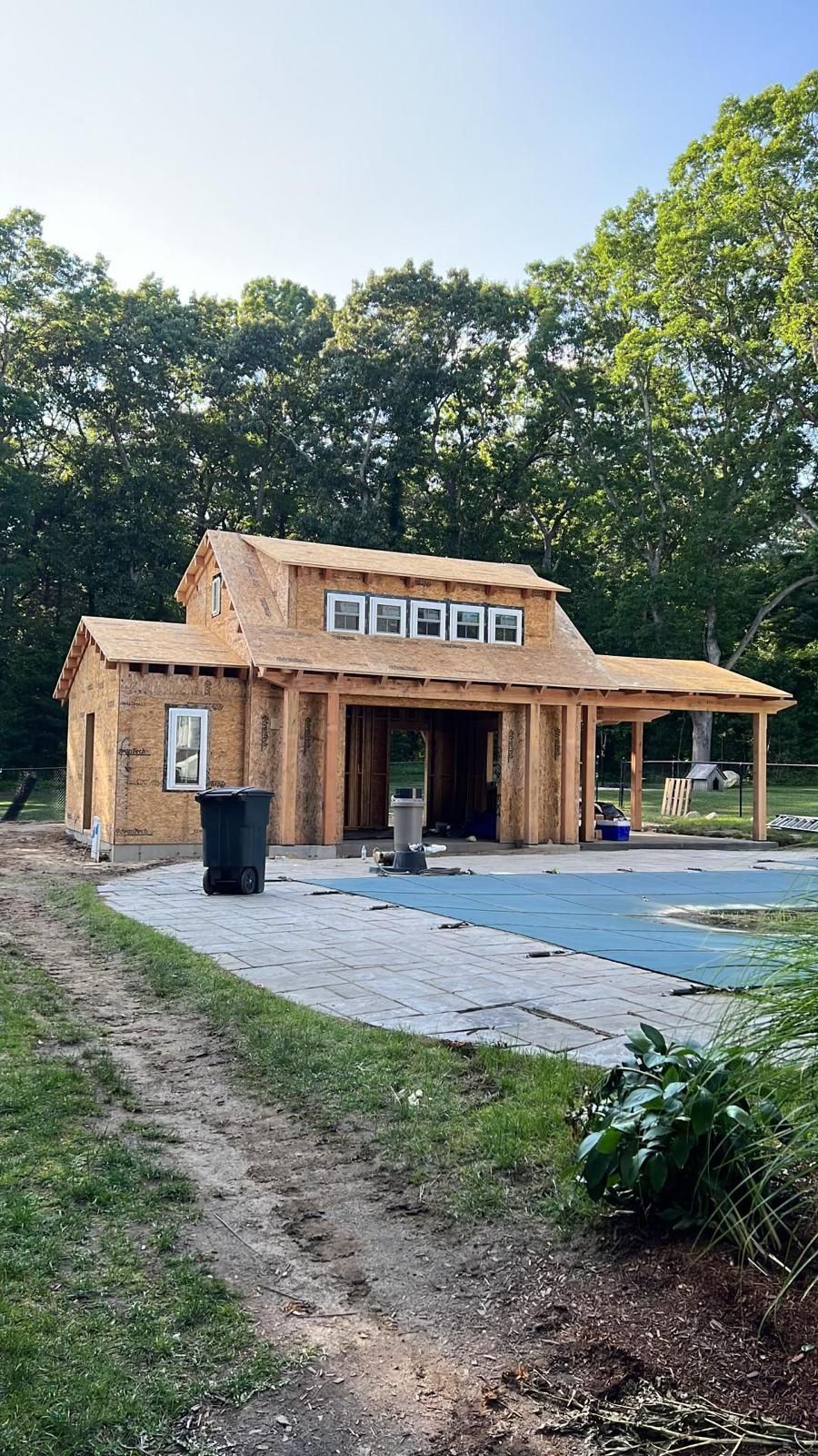 A house is being built next to a swimming pool.