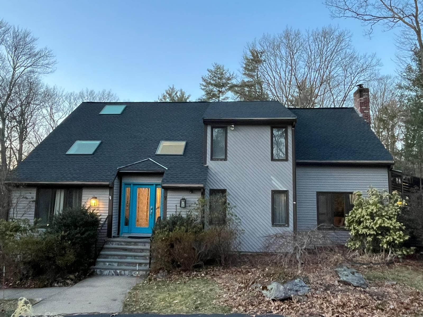 A large house with a blue door and a black roof