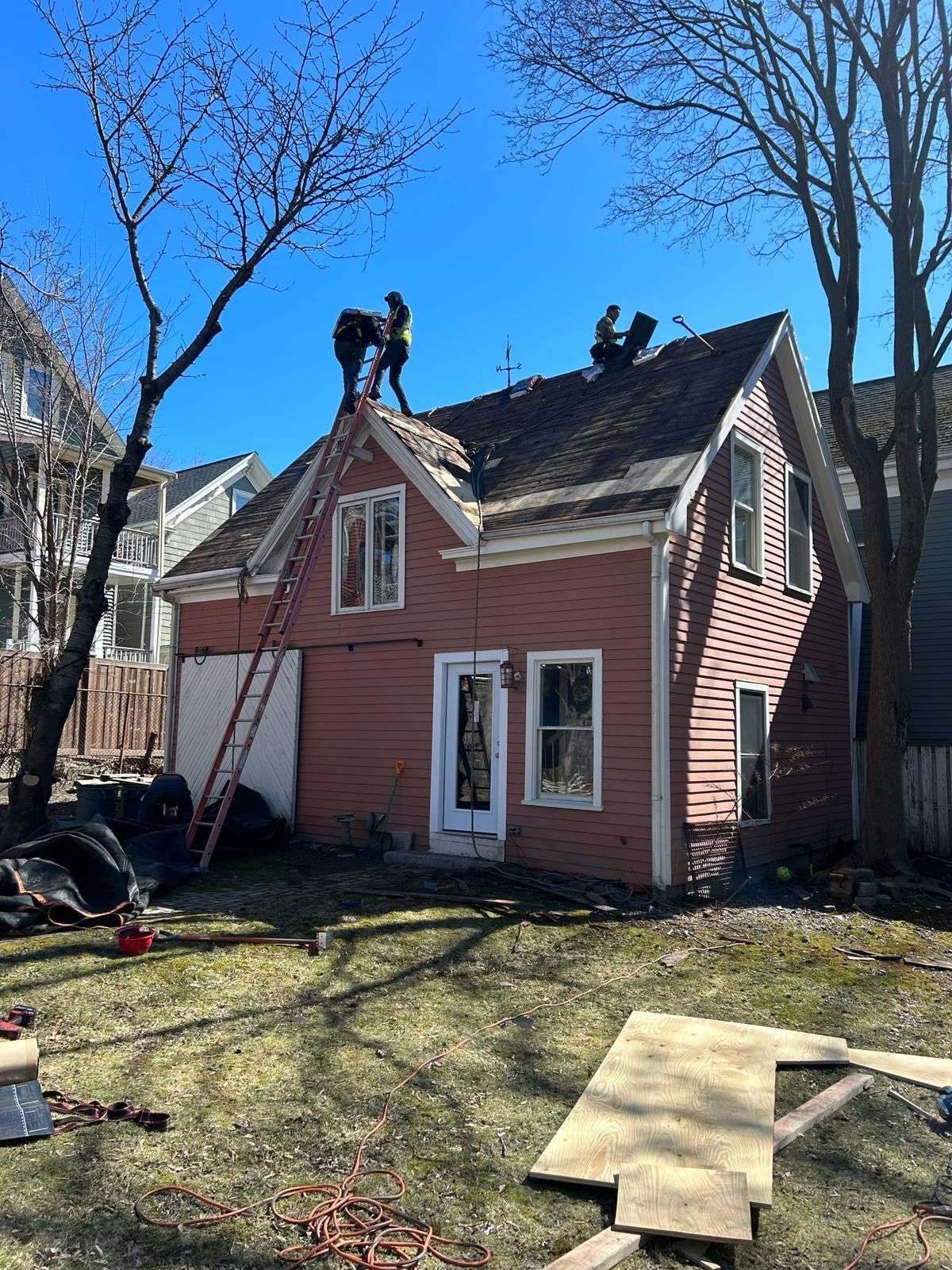 Two men are working on the roof of a house.