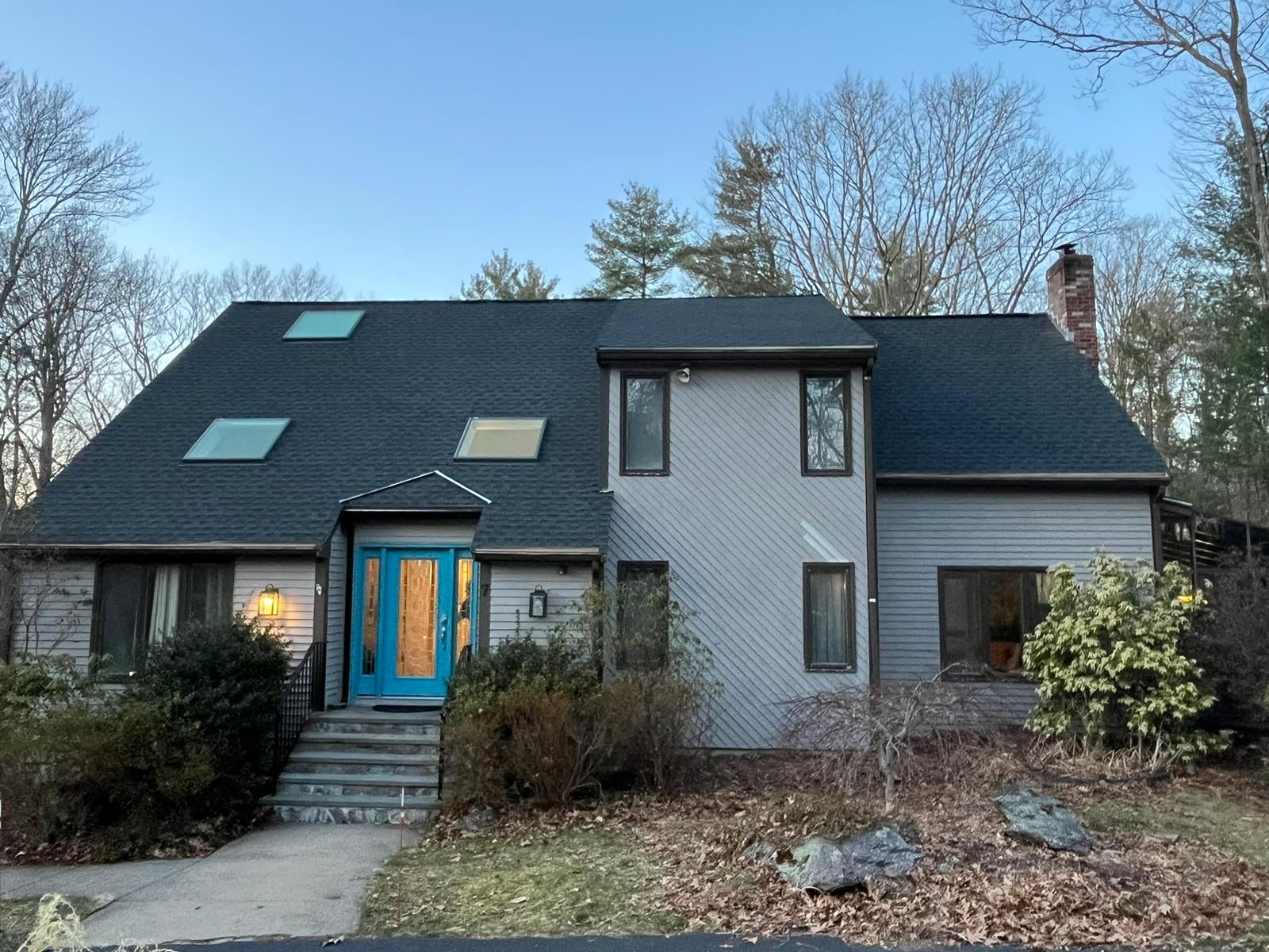 A house with a blue door and a black roof