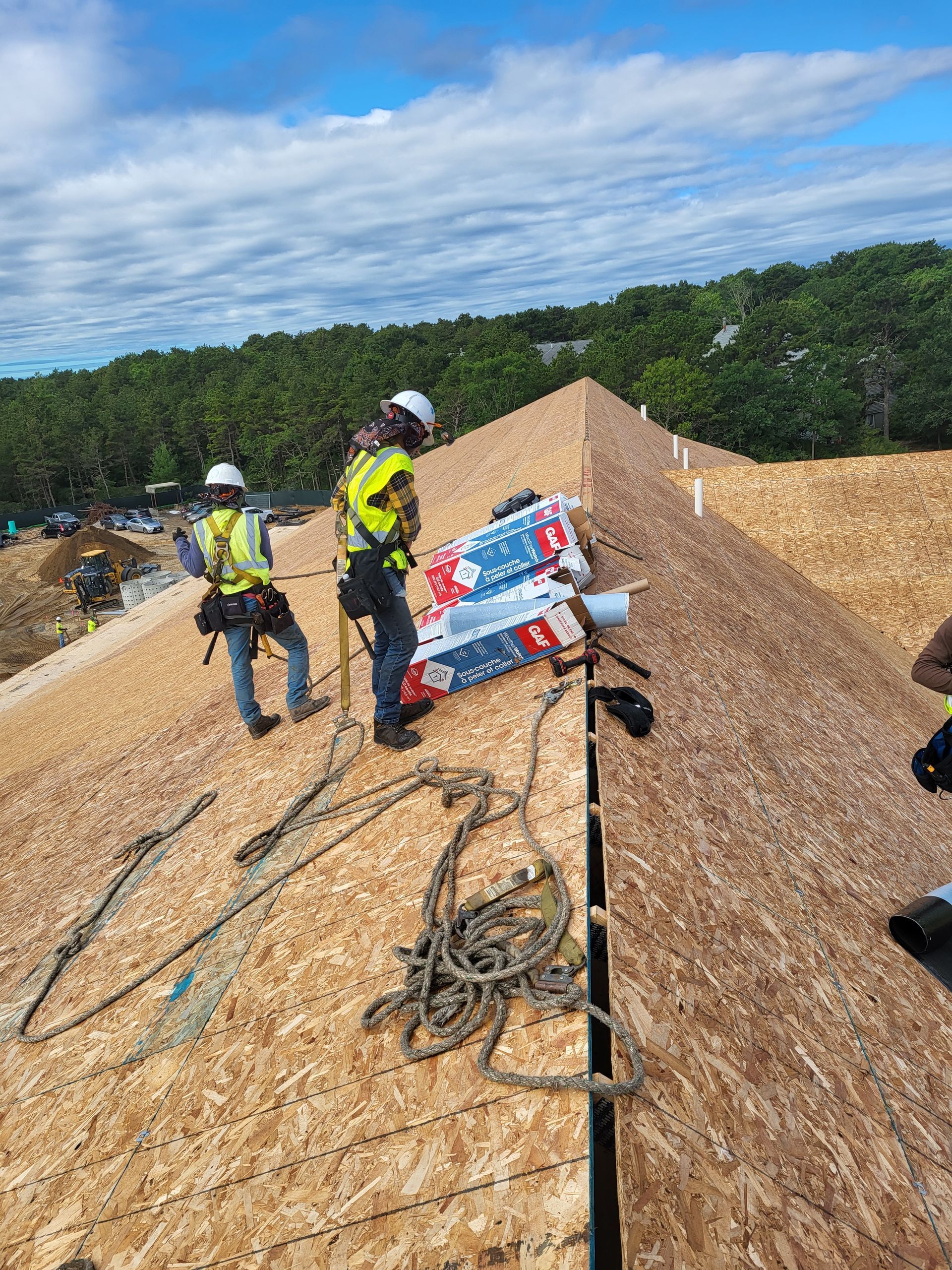 A group of construction workers are working on a roof.