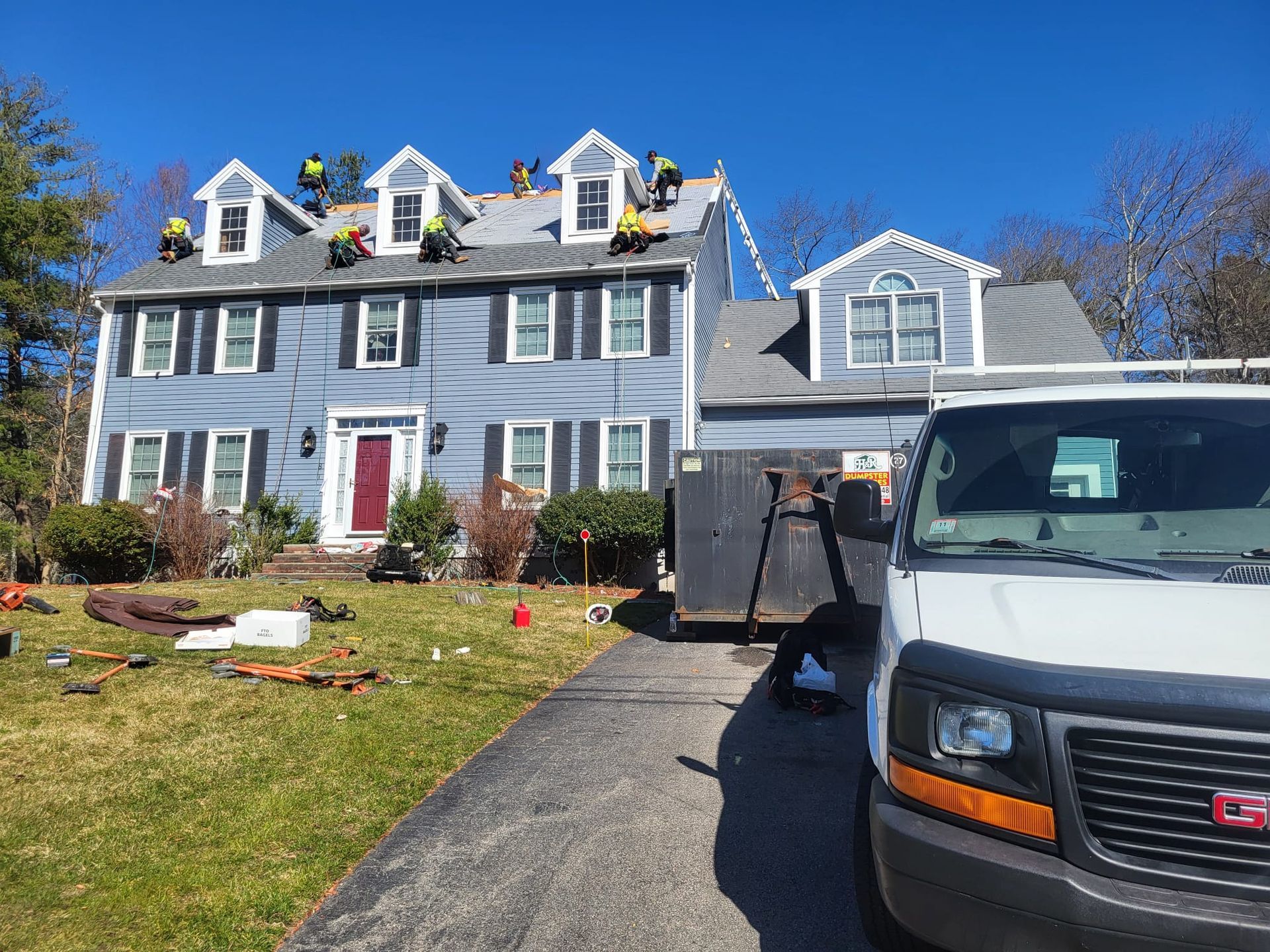 A white van is parked in front of a house that is being remodeled.