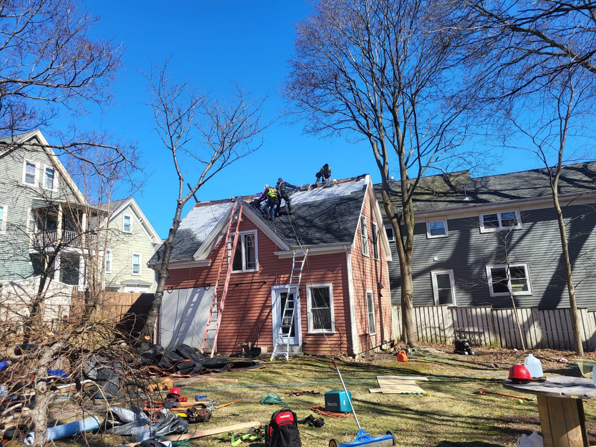 A group of people are working on the roof of a house.
