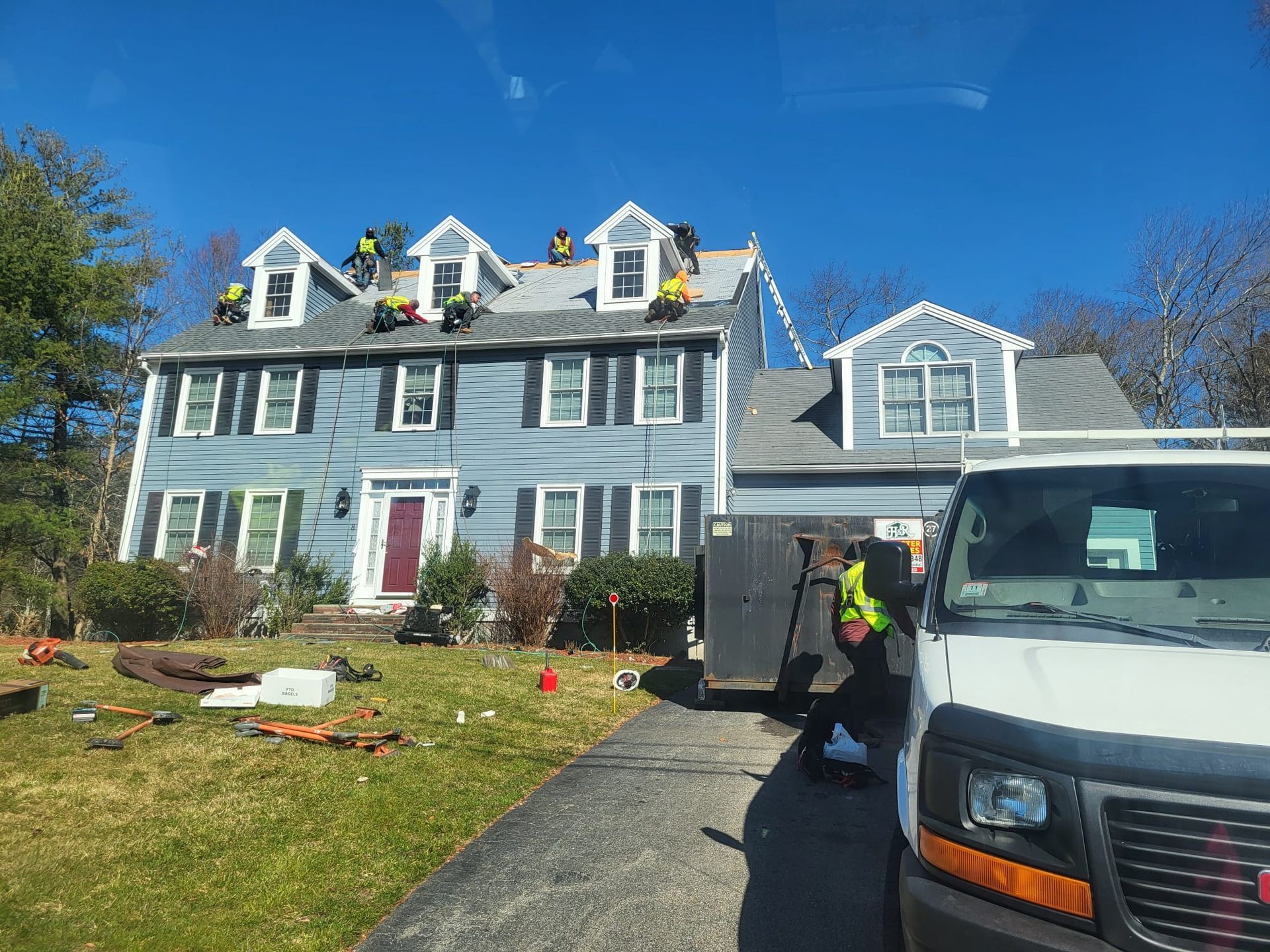 A white van is parked in front of a house that is being remodeled.
