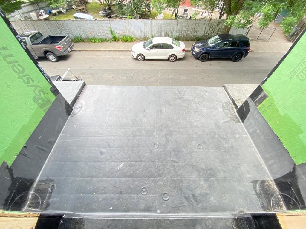 A car is parked on the side of the road next to a staircase.