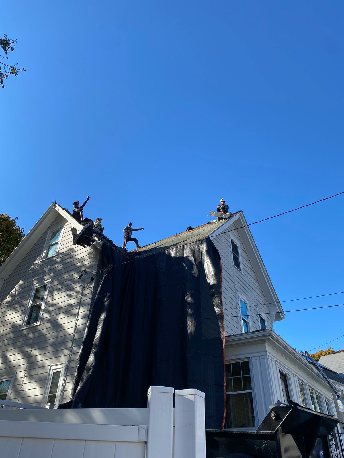 A group of people are working on the roof of a house.