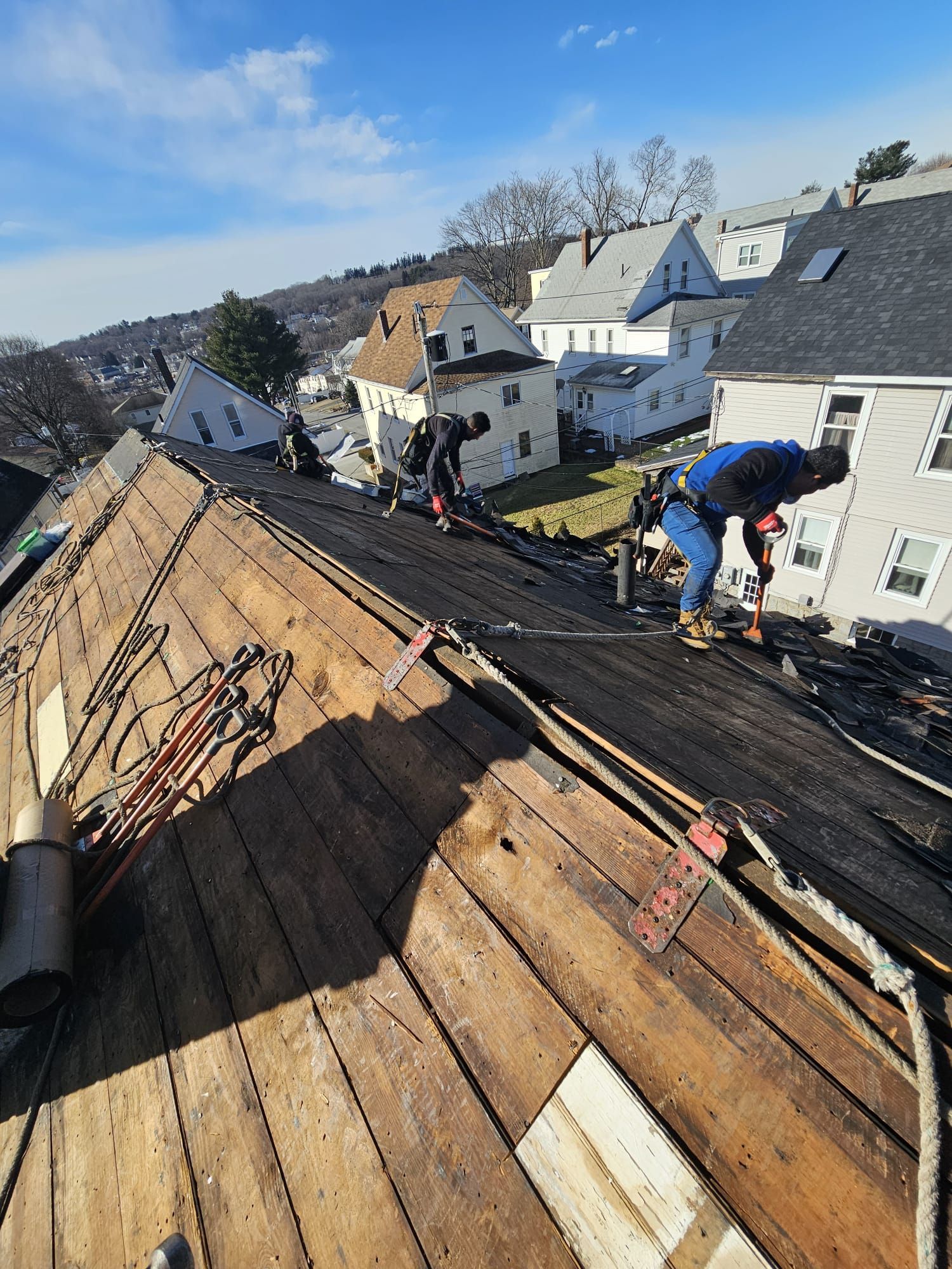 A group of men are working on the roof of a house.