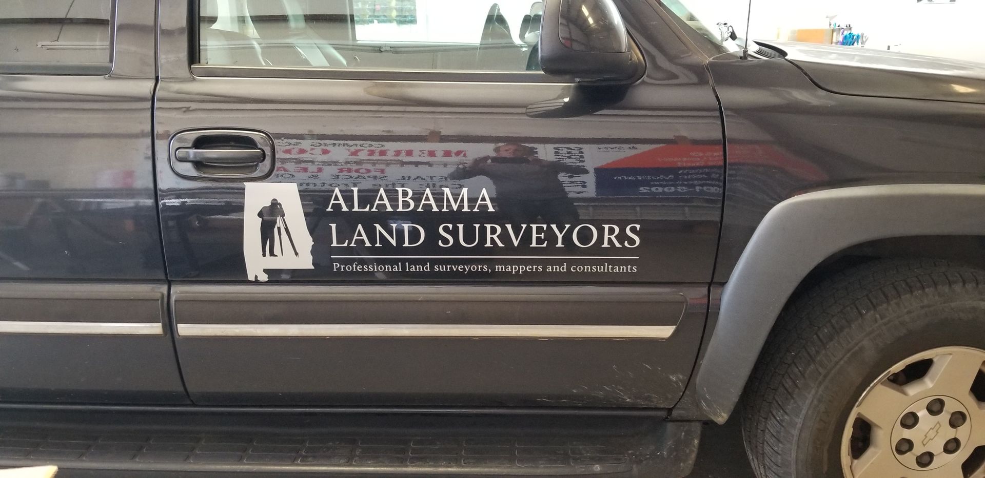 A black suv with alabama land surveyors written on the side