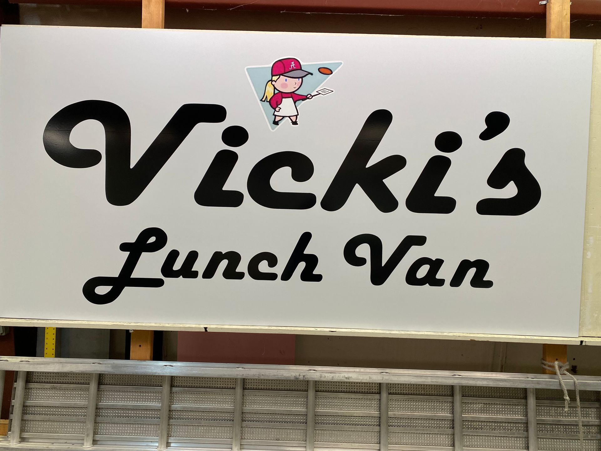 A white sign that says Vicki's lunch van