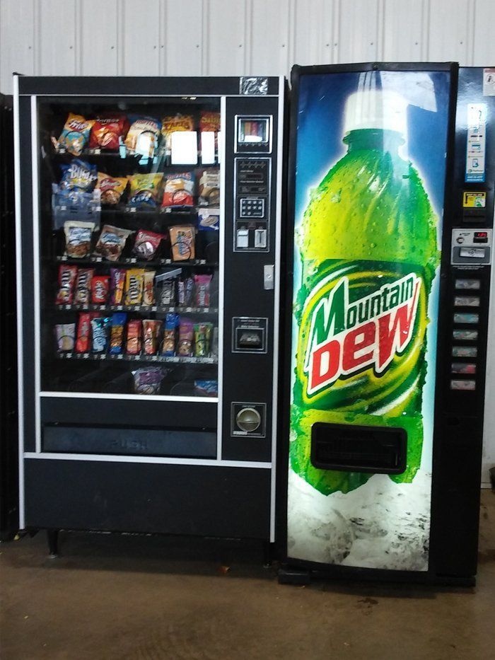 A mountain dew vending machine next to a snack machine
