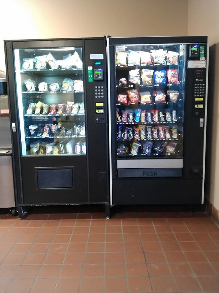 Two vending machines are next to each other on a tiled floor