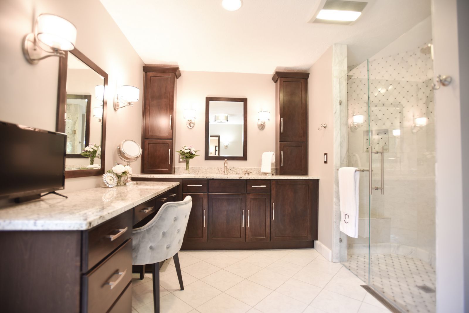 Modern bathroom with double vanity, wall mirror, and glass-enclosed shower.
