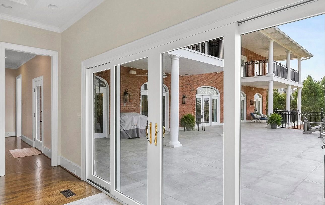 A large house with sliding glass doors leading to a patio.