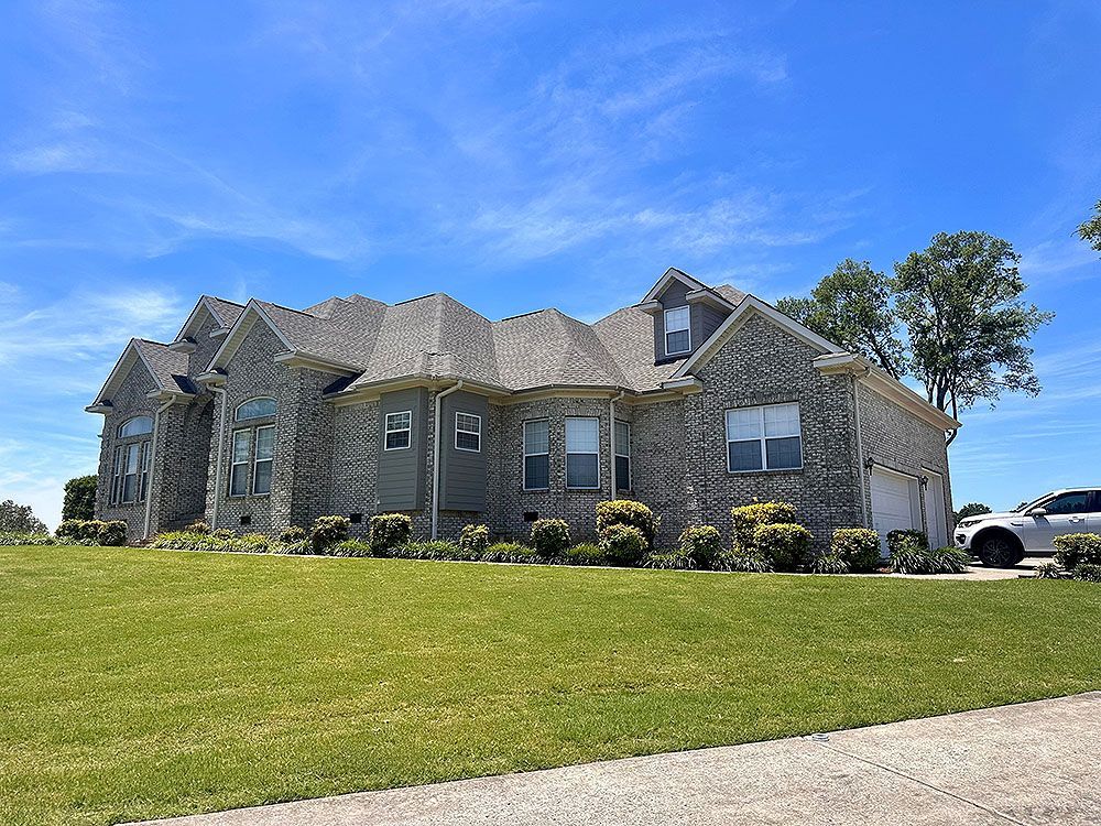 A large house with a lot of windows and a car parked in front of it.