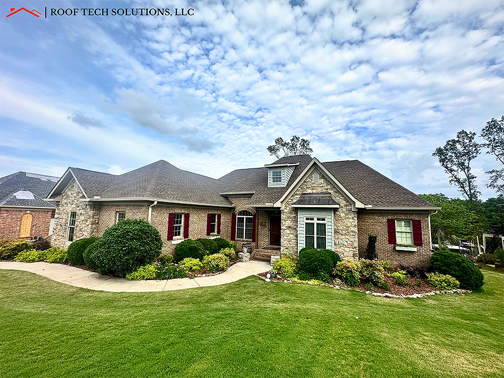 A large brick house with a lush green lawn in front of it.
