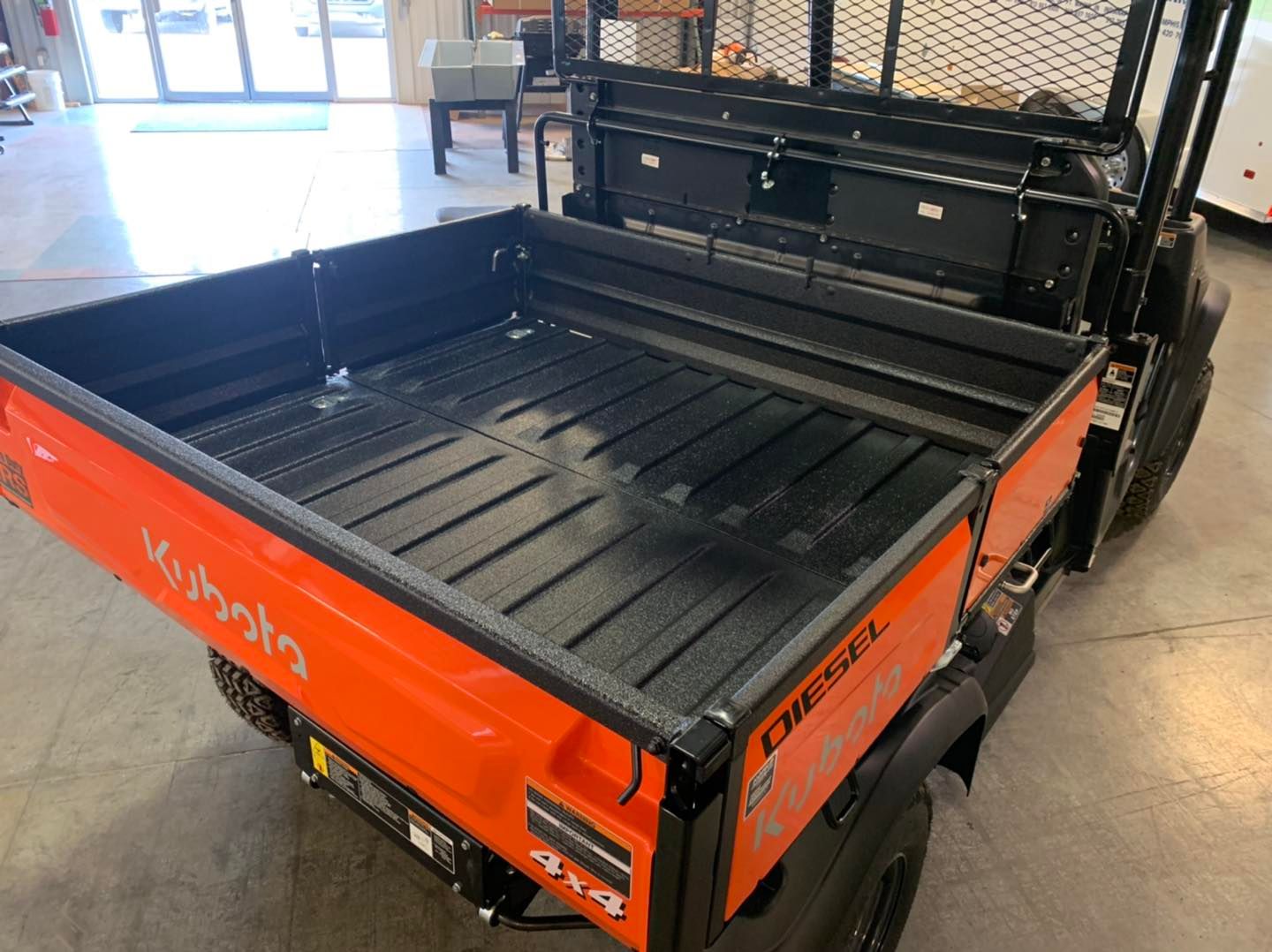 Orange Kubota utility vehicle with a black cargo bed. 