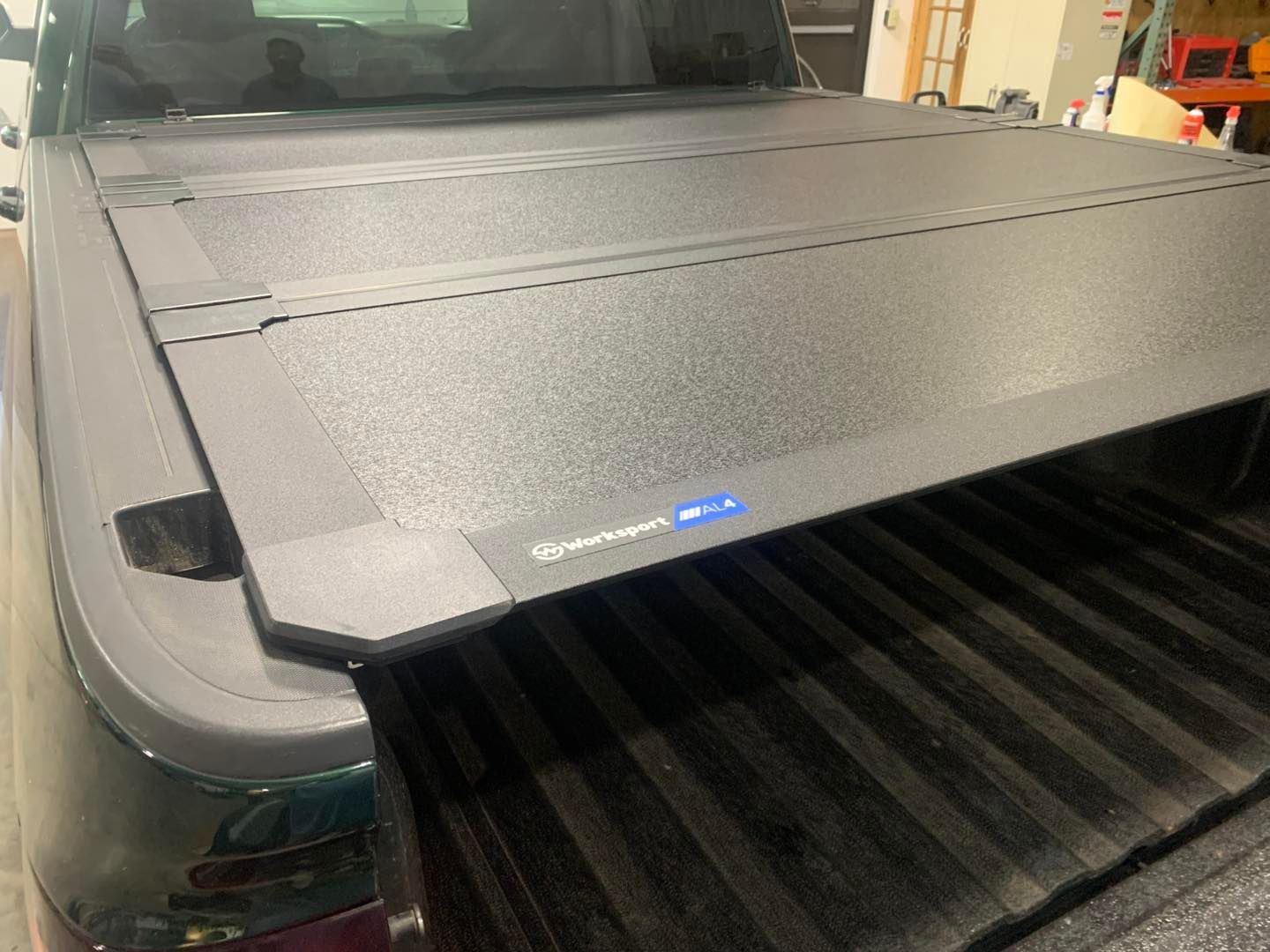 Black truck bed cover installed on a pickup truck.