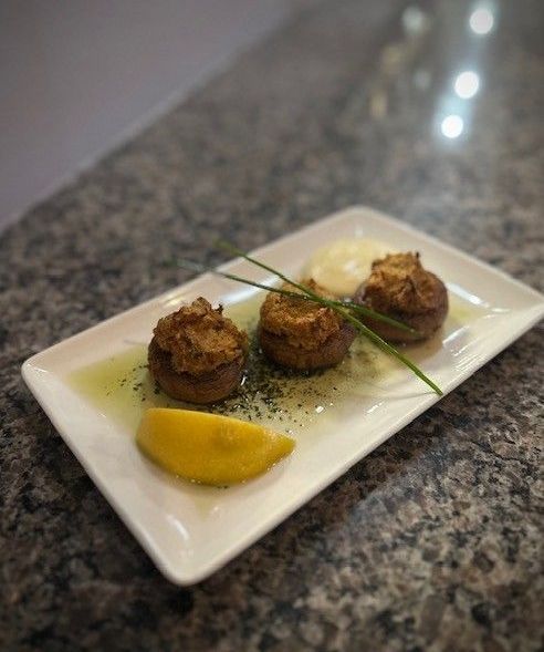 A plate of food with a lemon wedge on a table.