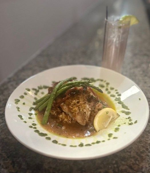 A plate of food with asparagus and a lemon on a table.
