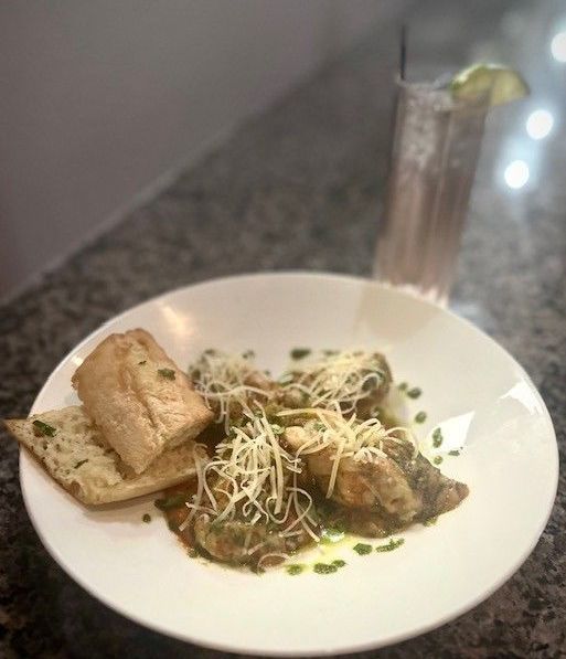 A plate of food with bread and cheese on a table next to a glass of water.
