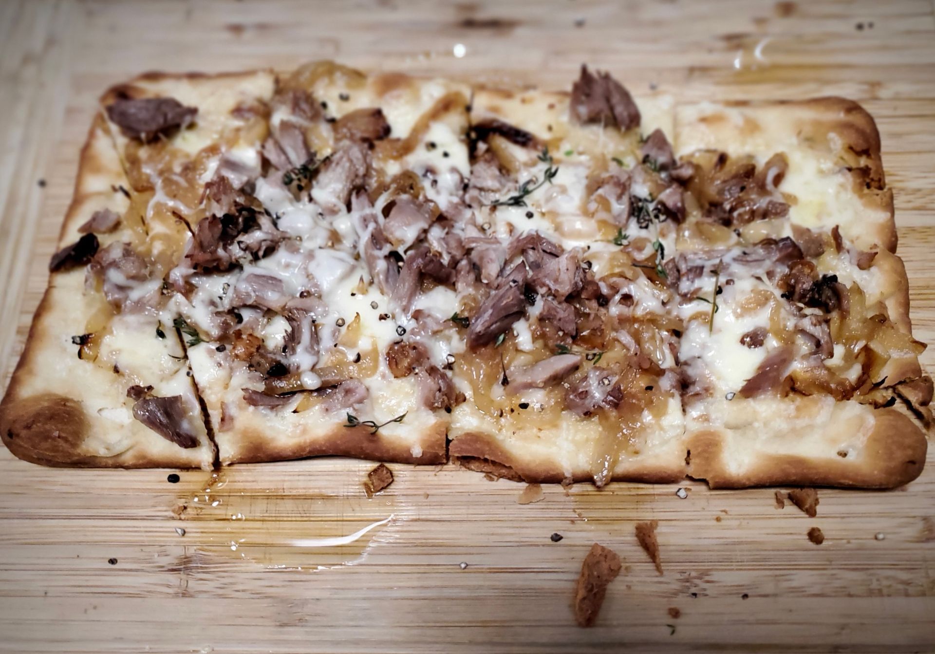 Duck Confit, Caramelized Onion, Gruyere, Thyme, and Black Pepper Flatbread