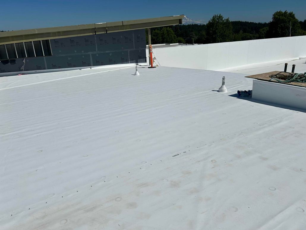 White flat roof on a building under a bright blue sky.