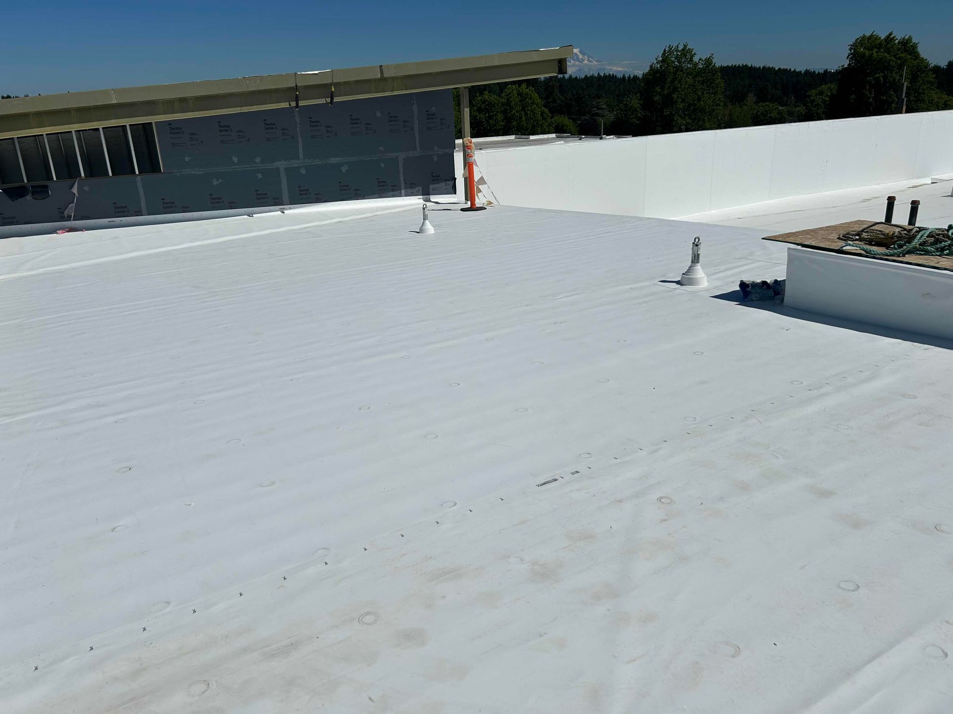 White flat roof on a building under a bright blue sky.