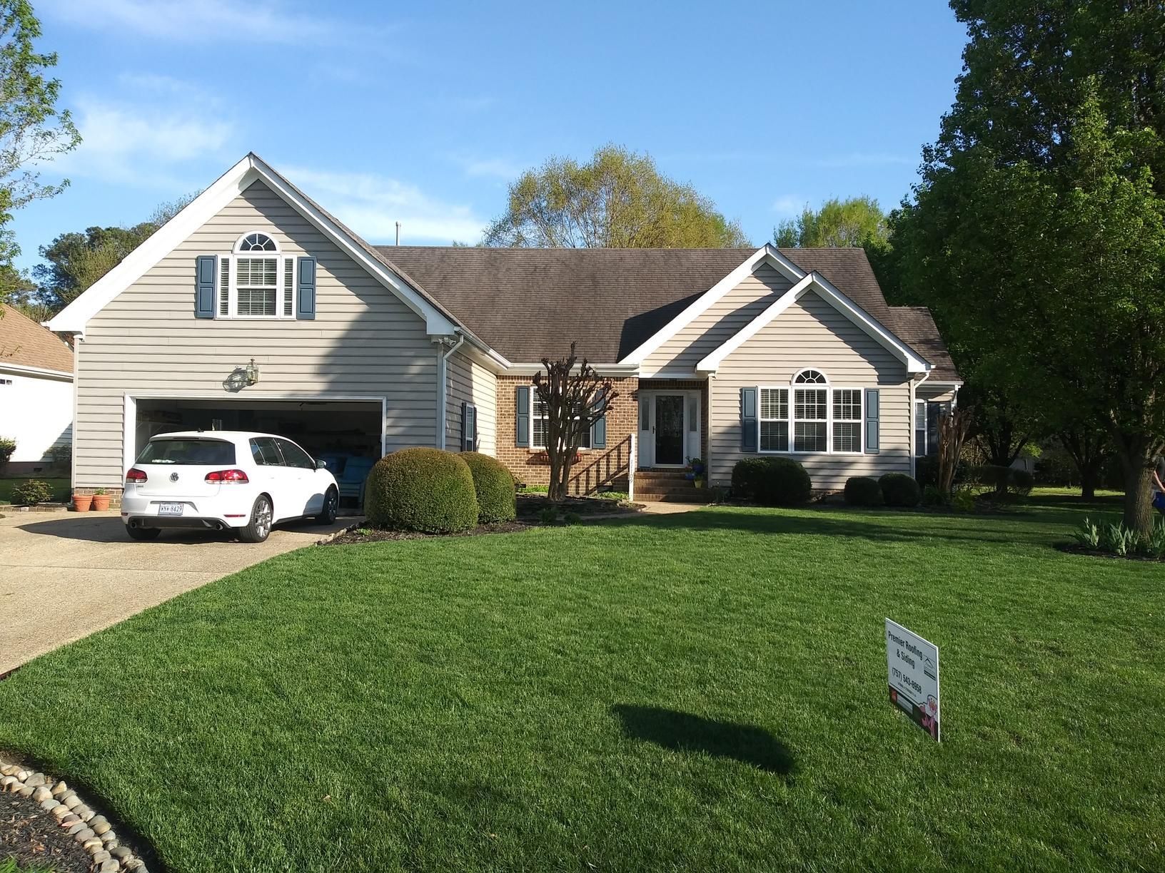 A white car is parked in front of a house