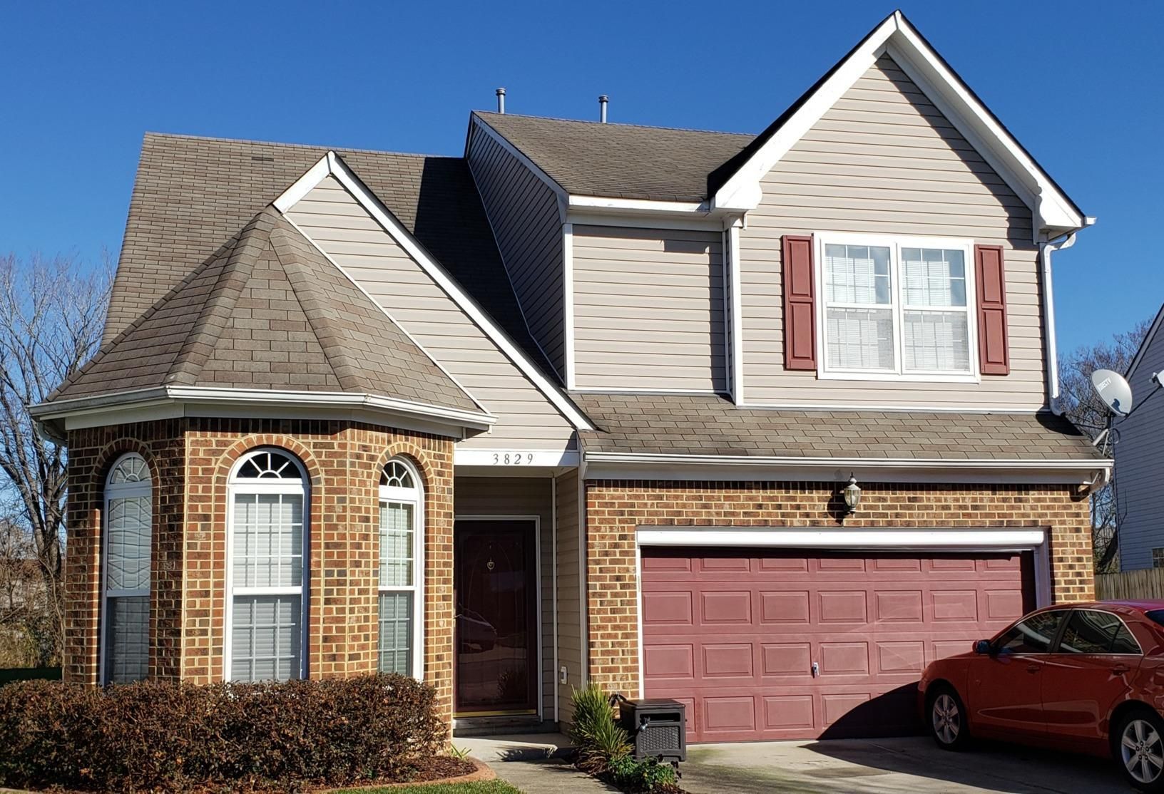 A large house with a red car parked in front of it
